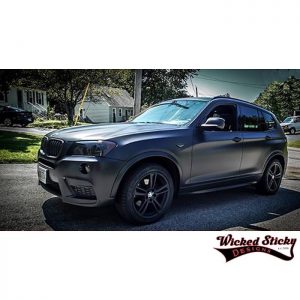 BMW X3 wrapped in Orafol 970RA Matte Black vinyl and 8300 Transparent Dark Grey on the headlamps