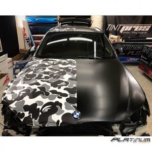 BMW wrapped in custom printed camo on 3M 40C vinyl and the right side in 3M 1080 Satin Black vinyl