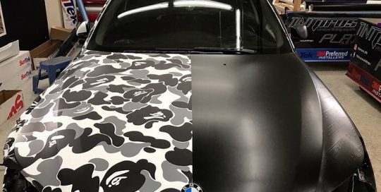 BMW wrapped in custom printed camo on 3M 40C vinyl and the right side in 3M 1080 Satin Black vinyl