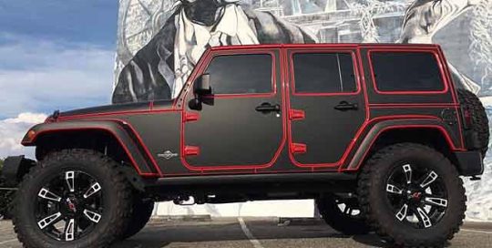 Jeep Wrangler wrapped in Avery SW Matte Black vinyl using #knifelesstape to expose the red paint underneath