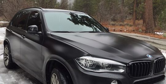 BMW X5M wrapped in Avery SW Satin Black vinyl