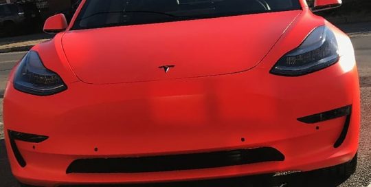 Tesla Model 3 wrapped in 3M Satin Neon Fluorescent Organe vinyl